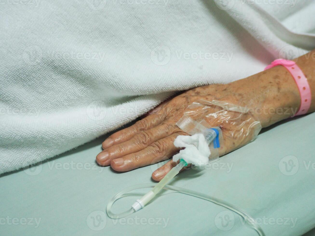 close-up de paciente de mão de mulher sênior internado no hospital foto