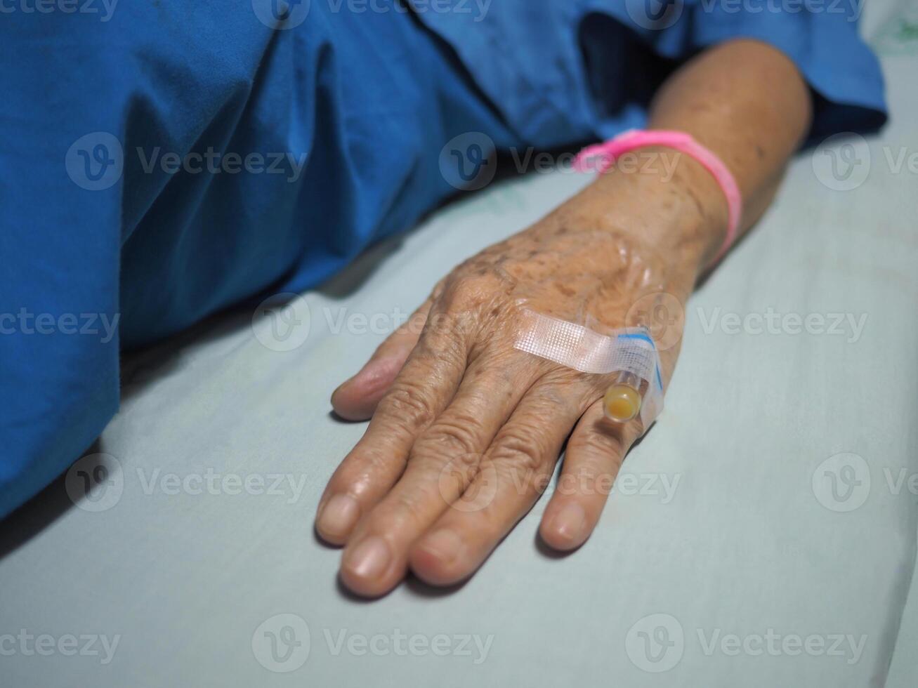 close-up de paciente de mão de mulher sênior internado no hospital foto