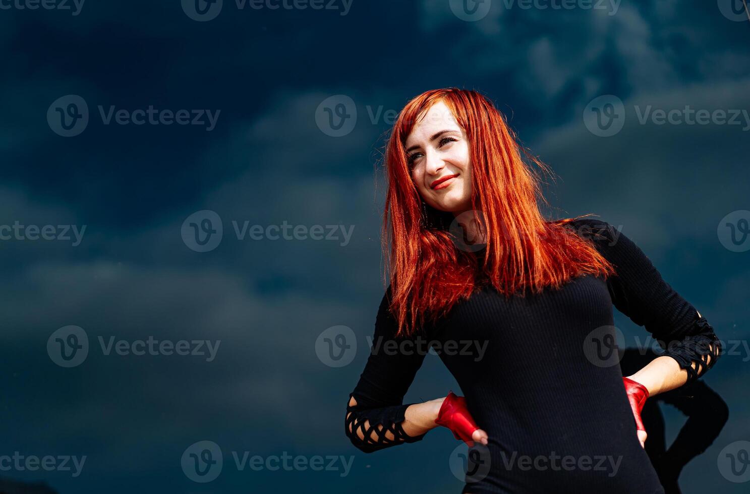 uma mulher com vermelho cabelo posando para uma cenário foto