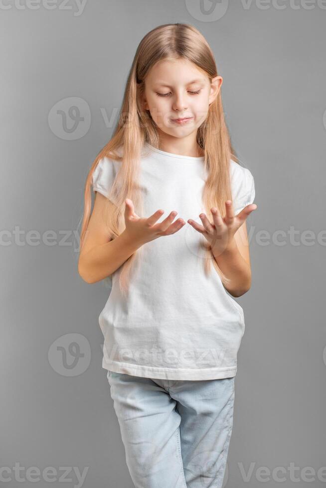 fofa pequeno menina olhando às dela mãos foto