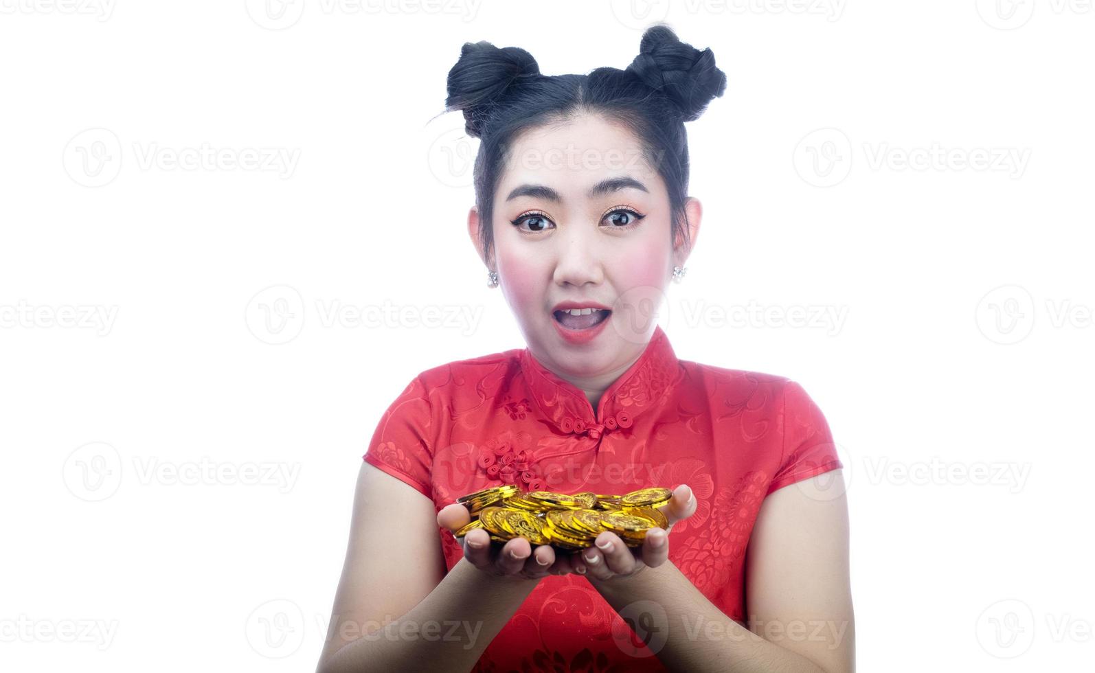 retrato asiático jovem, mulher vestido vermelho tradicional cheongsam segurando uma moeda de ouro no fundo branco foto