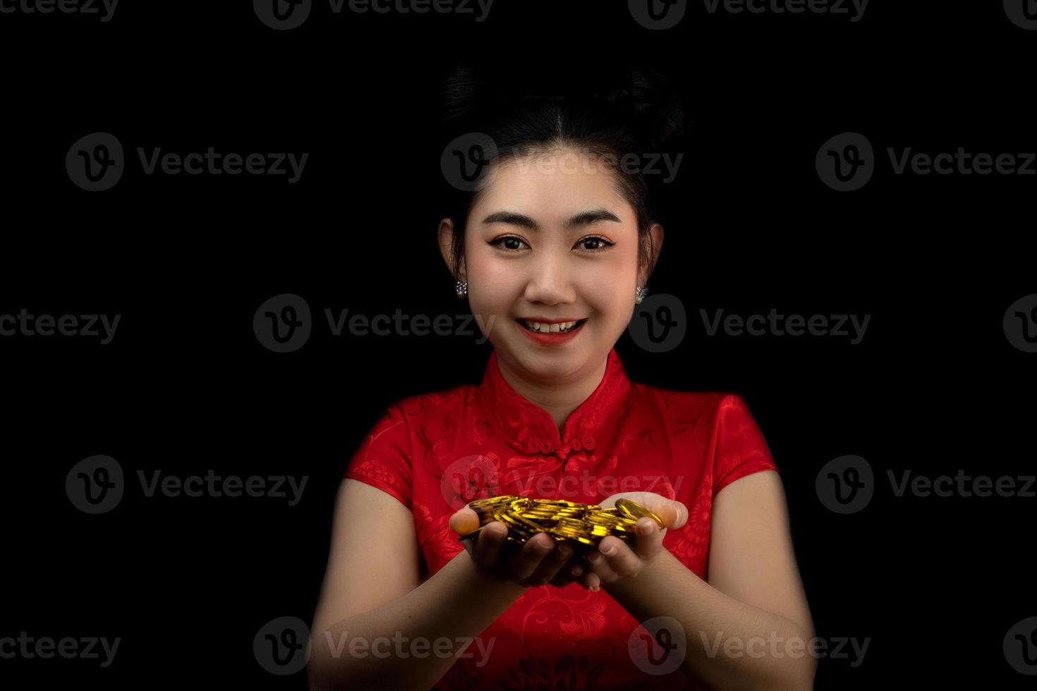 retrato asiático jovem, mulher vestido vermelho tradicional cheongsam segurando uma moeda de ouro em fundo preto, foto