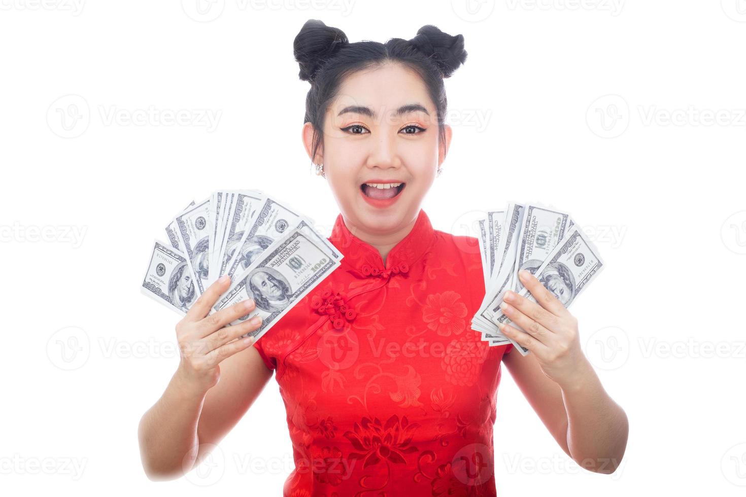 retrato mulher asiática vestido vermelho cheongsam tradicional segurando dinheiro notas de 100 dólares americanos em fundo branco foto