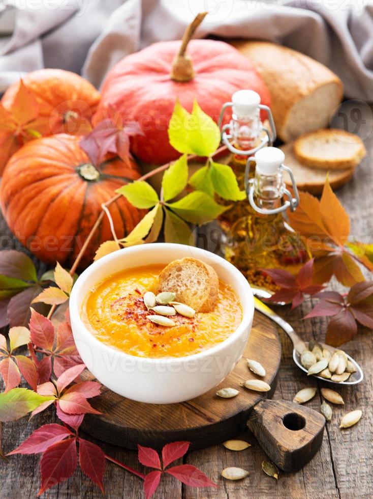 tigela de sopa de abóbora em fundo de madeira rústico foto