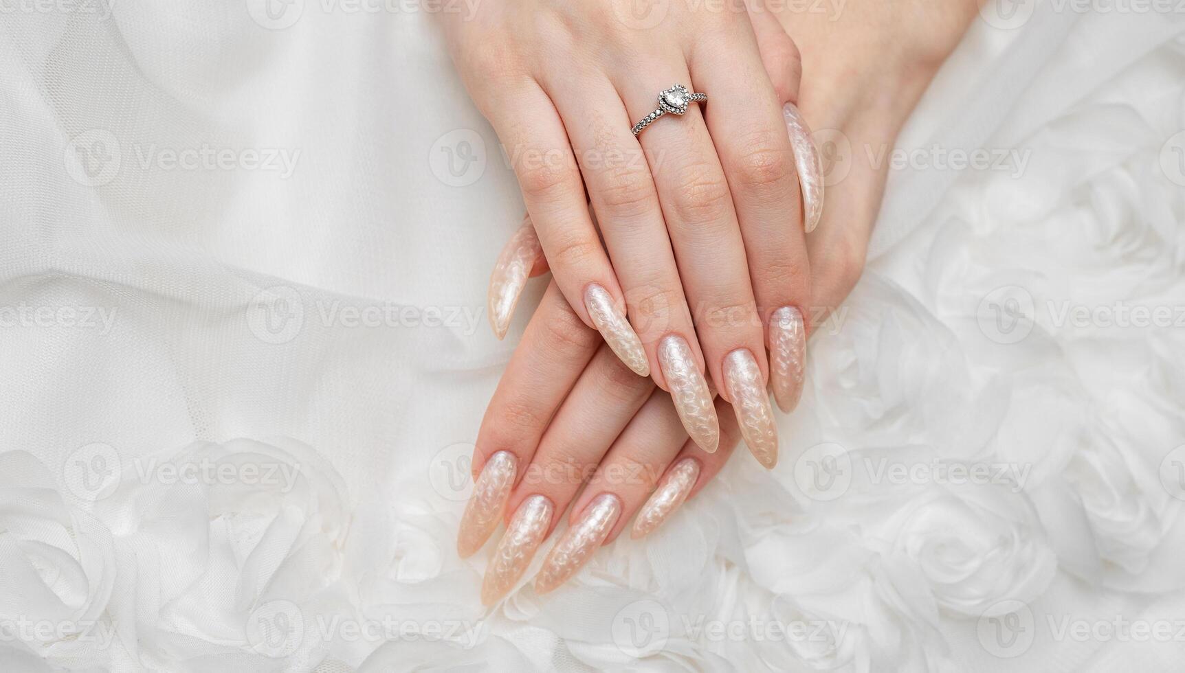 mão do uma jovem mulher com branco pérola manicure foto