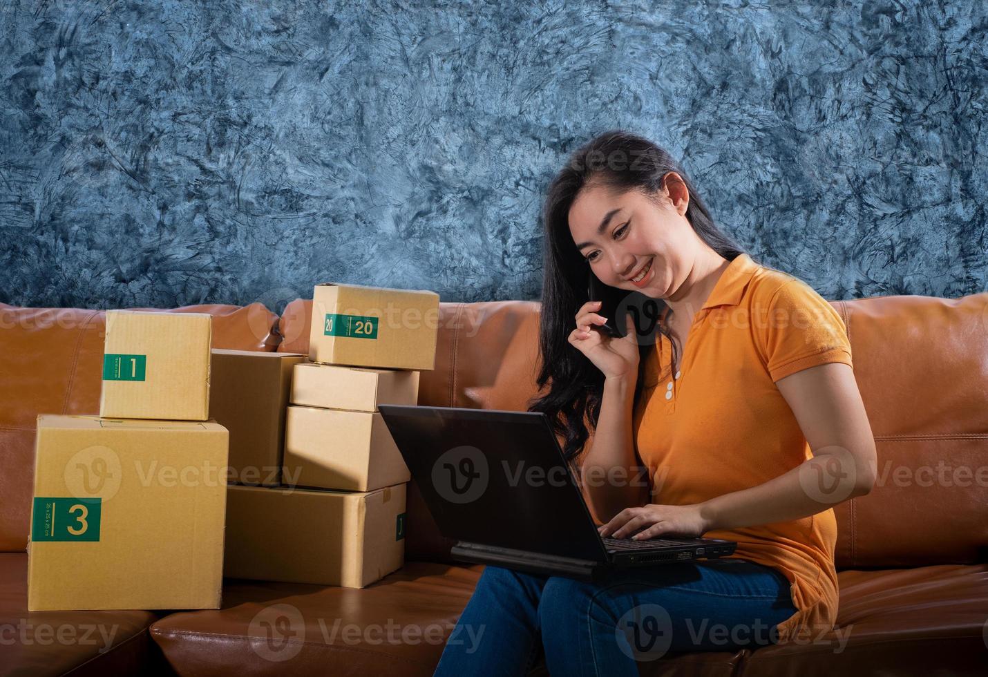 retrato entediado jovem asiático está sentado no sofá em seu quarto, as mulheres usaram o telefone celular no fundo da parede de concreto, uma senhora está entediada porque as vendas caíram em relação ao conceito de meta de vendas foto