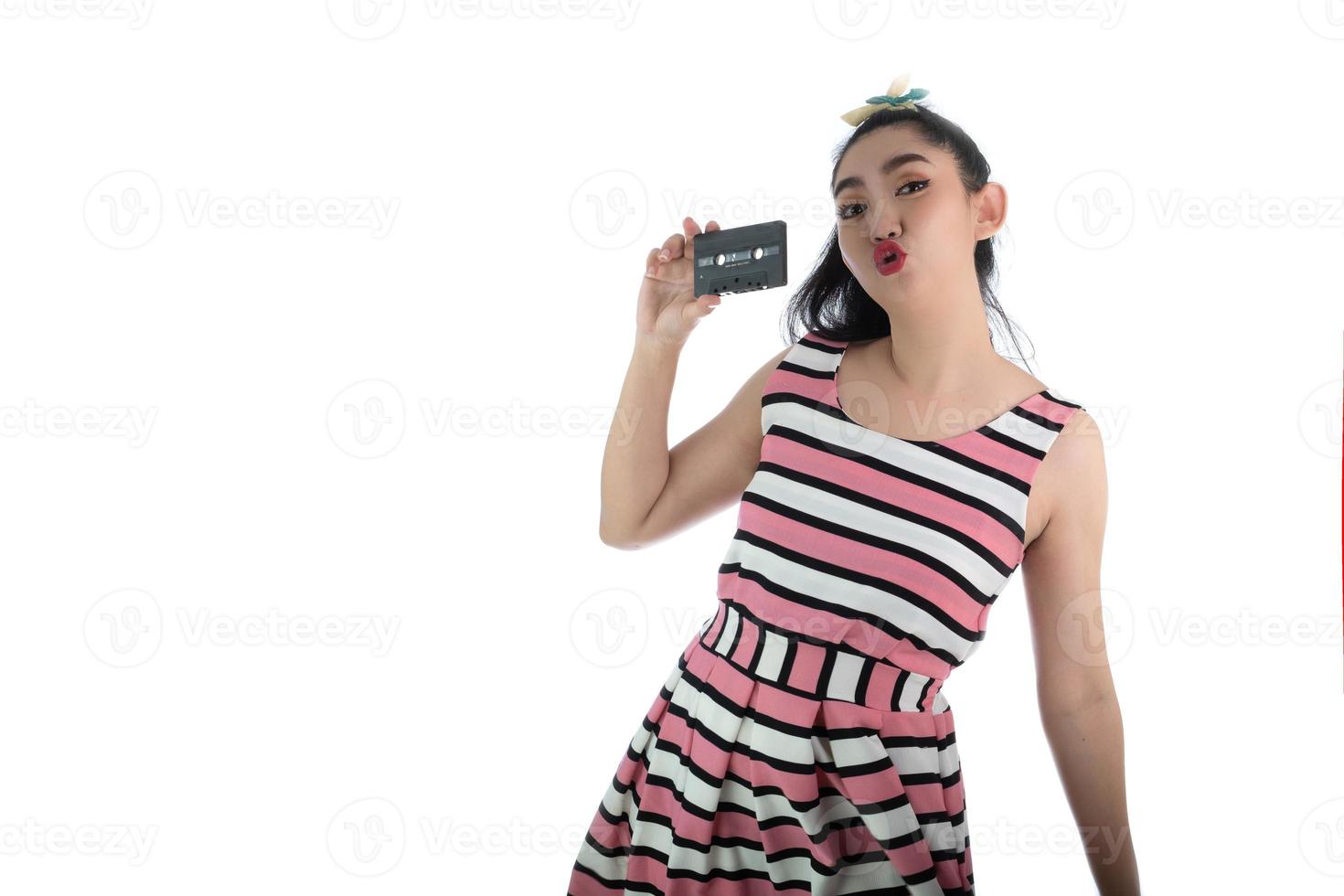 jovem asiática com vestido rosa estilo retrô segurando uma fita cassete em  um fundo branco 3814402 Foto de stock no Vecteezy