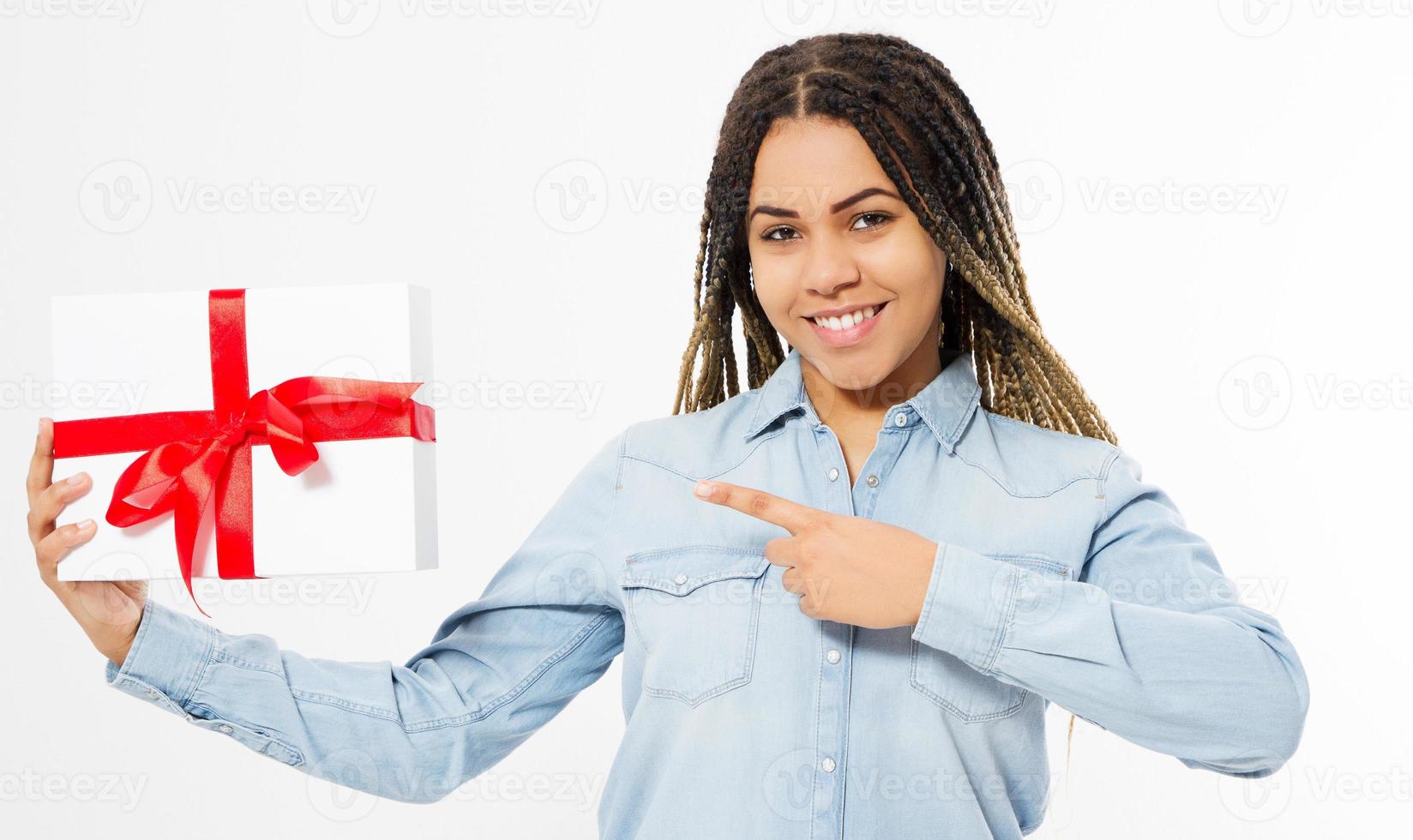 garota negra feliz apontada na caixa de presente sobre fundo branco, feriados comemorativos foto