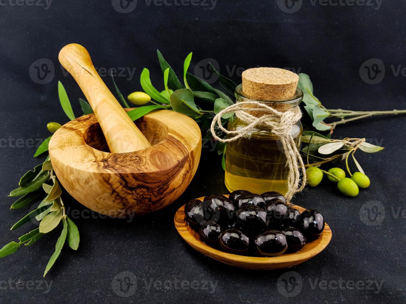 azeite de oliva prensado a frio com galho e frutas foto