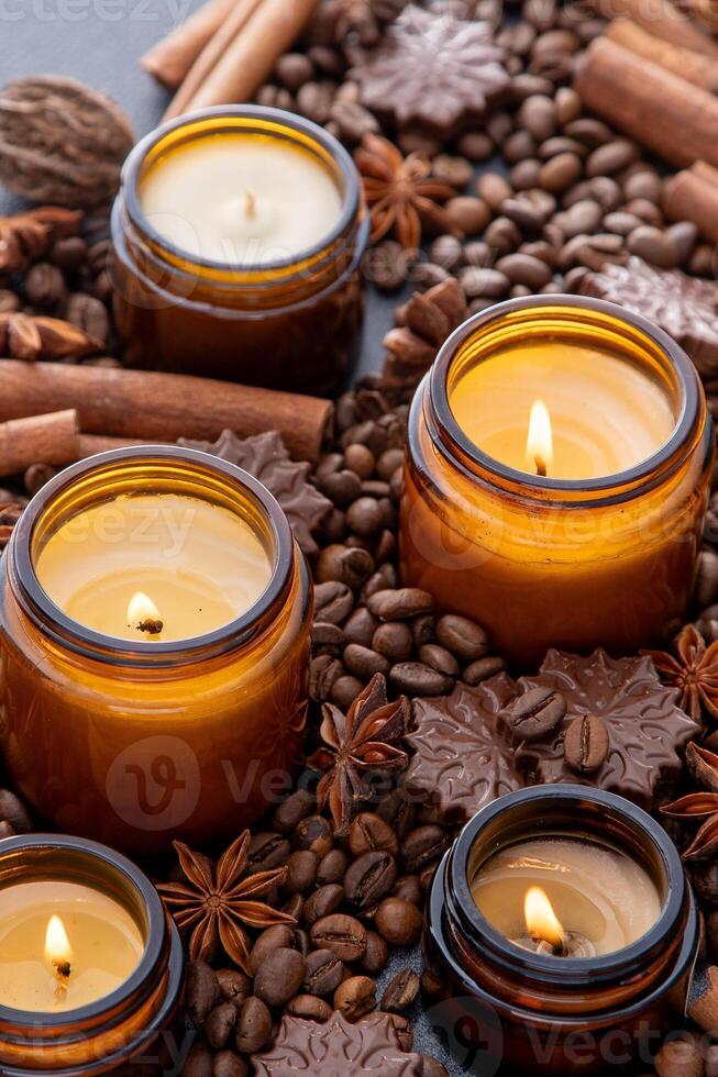 soja perfumado vela dentro uma jar. café feijões, anis, canela especiarias. a velas estão queimando. Sombrio fundo. foto