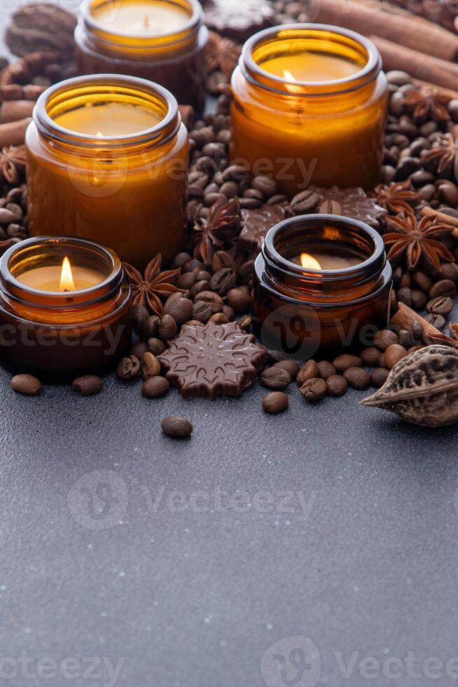 soja perfumado vela dentro uma jar. café feijões, anis, canela especiarias. a velas estão queimando. Sombrio cópia de espaço fundo. foto