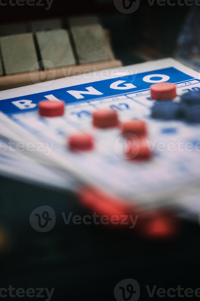 fechar-se Visão do uma Bingo cartão e vermelho marcadores durante uma jogos sessão foto