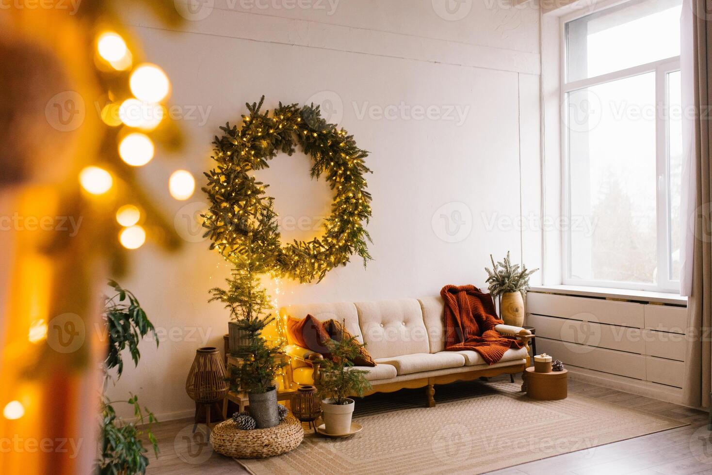 fabuloso Natal interior do a estilo escandinavo vivo quarto com uma sofá, almofadas e Natal árvores com uma guirlanda em a parede foto