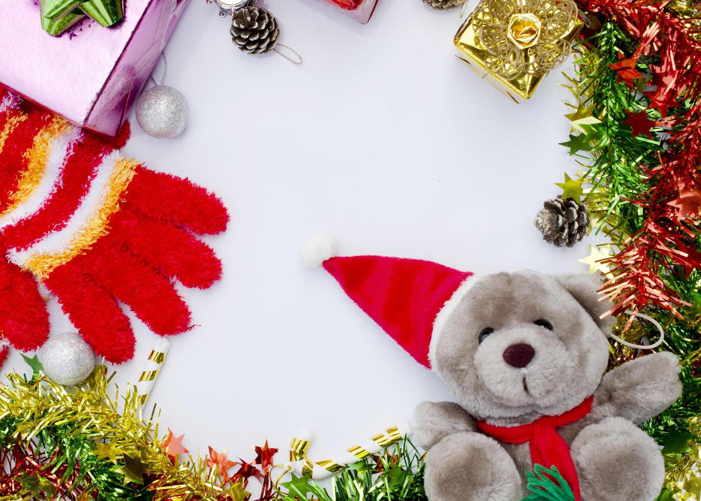 moldura de natal com decoração de pelúcia e luvas vermelhas de malha em fundo branco acima foto