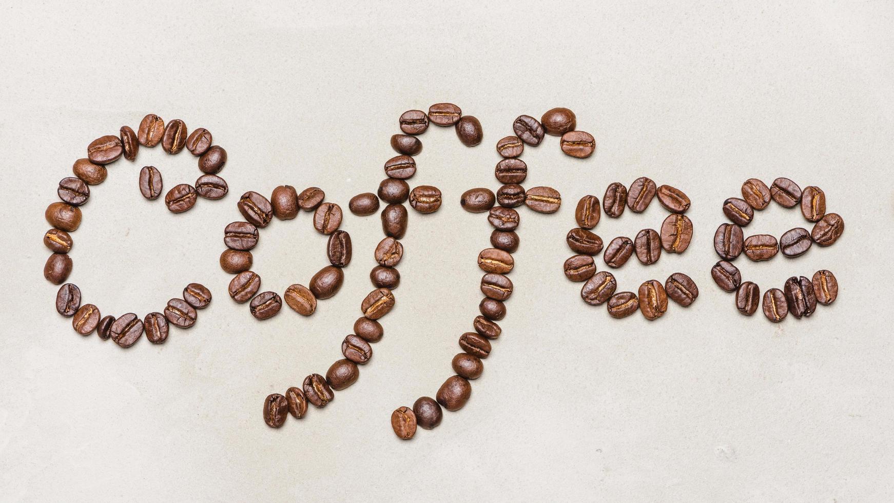a palavra café é feita de grãos de café. sobre um fundo branco. copiar palavra espaço café foto