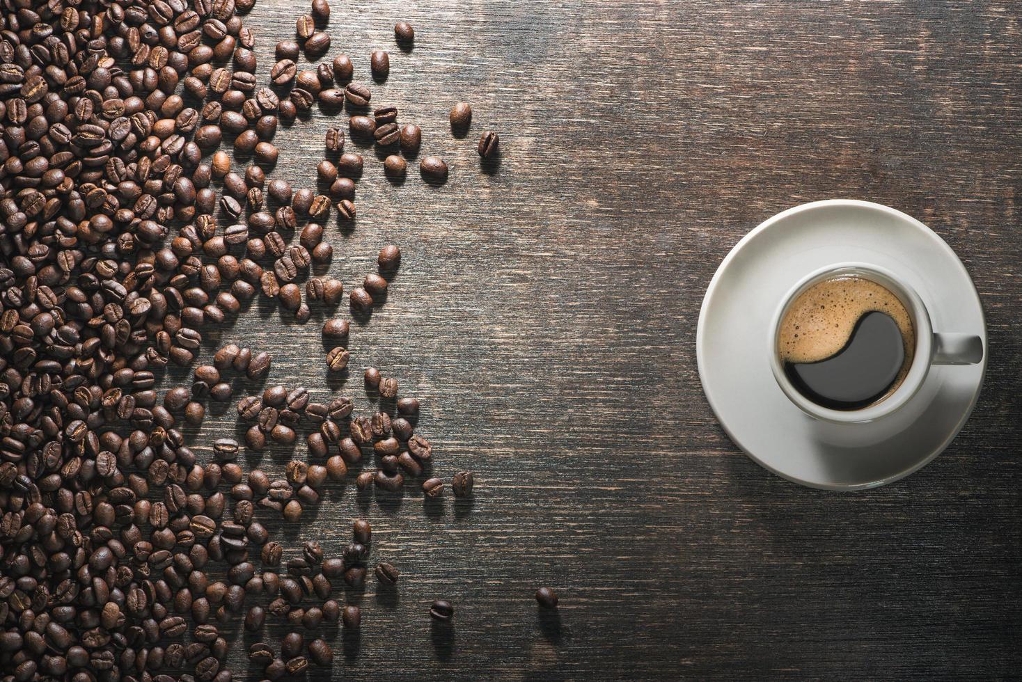 xícara de café com grãos de café na velha mesa foto