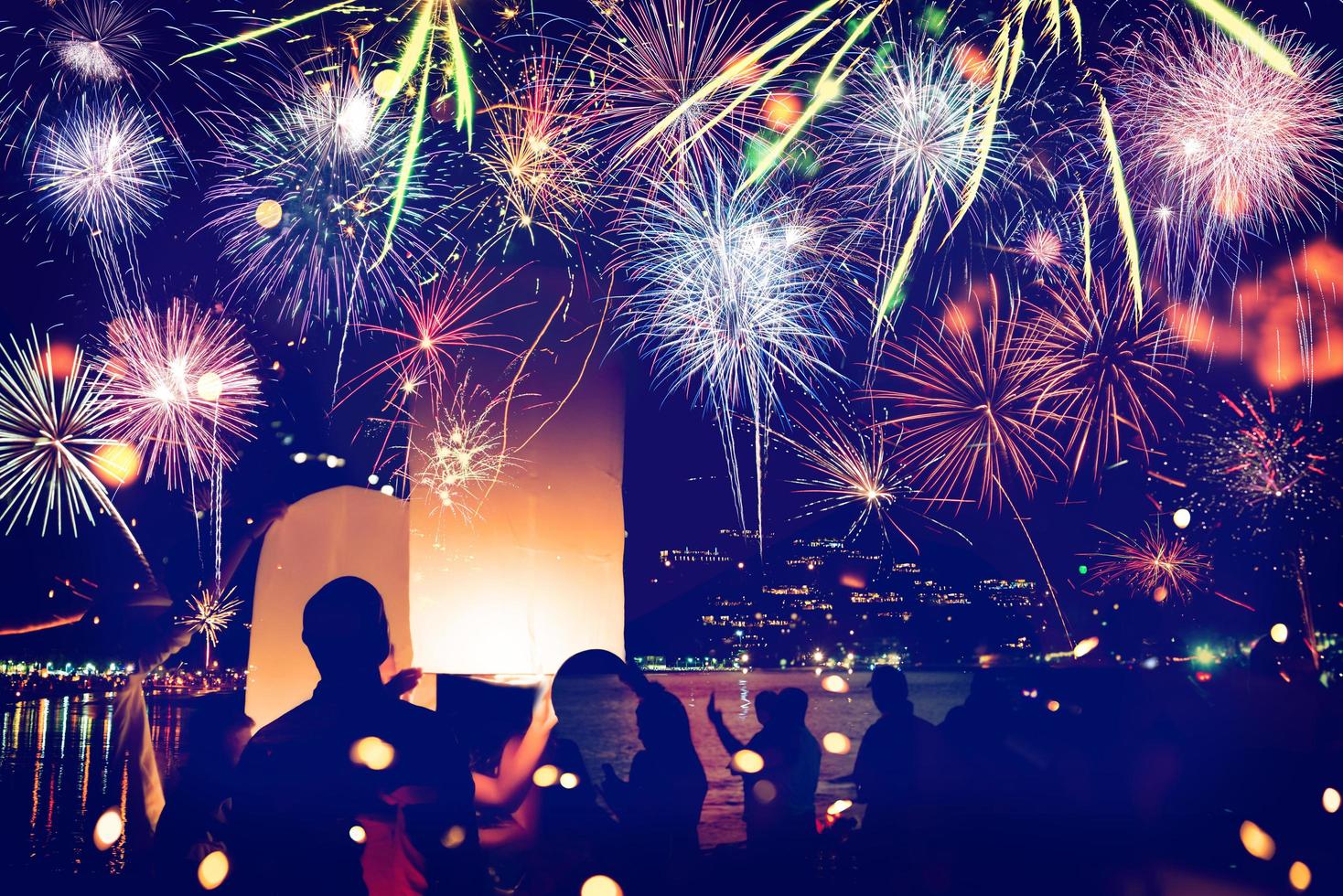 fogos de artifício com silhuetas de pessoas em um feriado events.new ano fogos de artifício na praia. viajantes e pessoas comemoram o ano novo em kamala beach phuket, tailândia. foto
