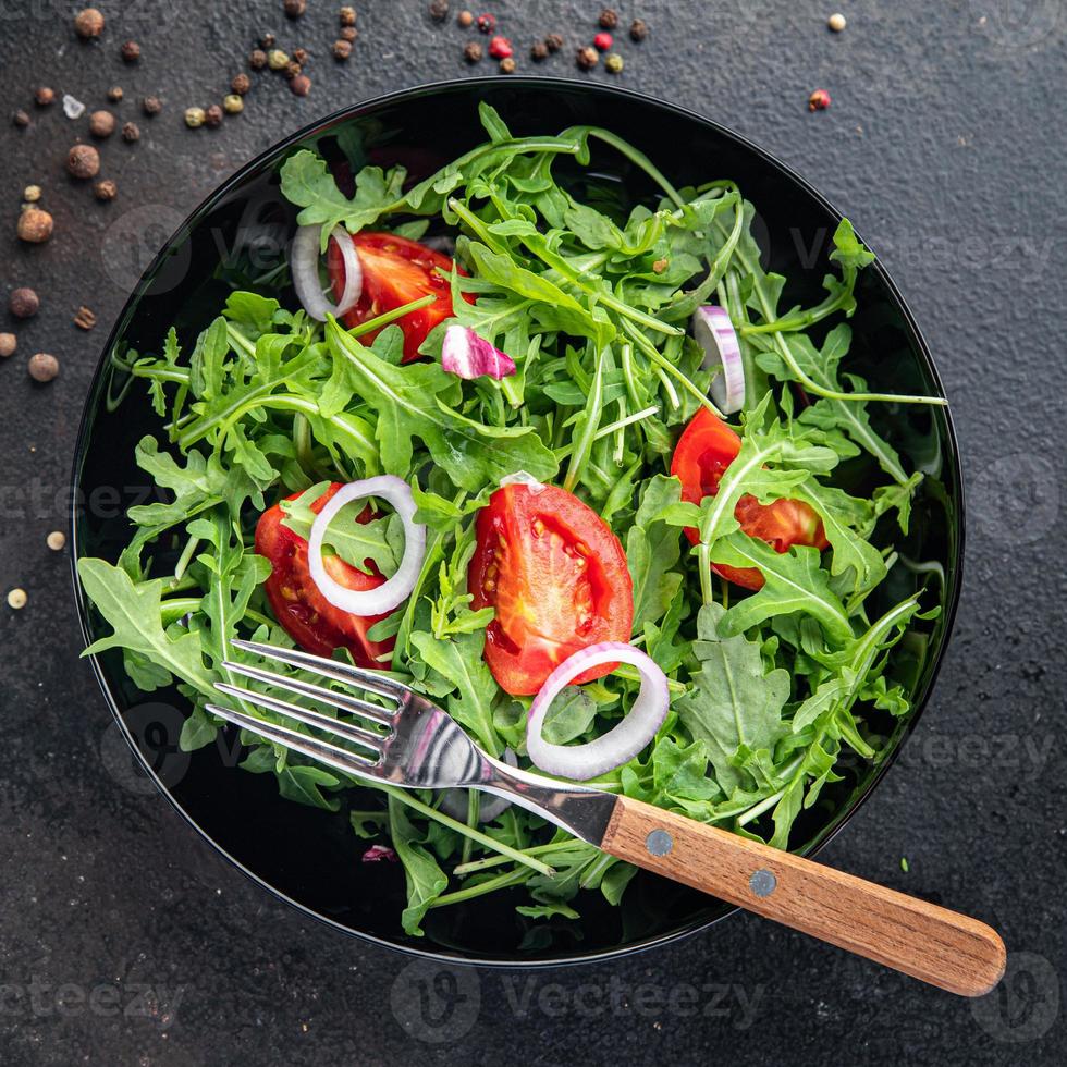 salada de vegetais frescos rúcula, tomate, cebola prato refeição lanche na mesa cópia espaço fundo de alimentos foto
