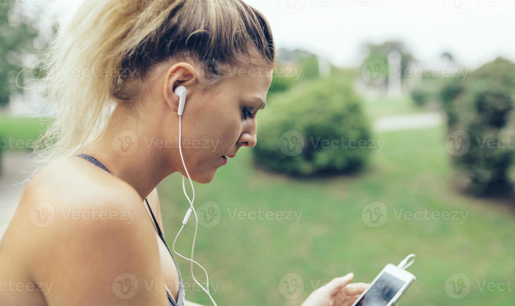 mulher com fones de ouvido ouvindo música no smartphone foto