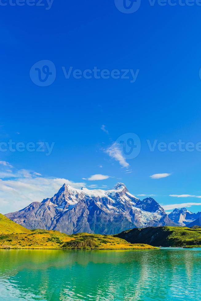 picos de torres vistos de pehoe lago com águas turquesa no parque nacional de torres del paine, patagônia, chile, em dia de sol e céu azul. foto