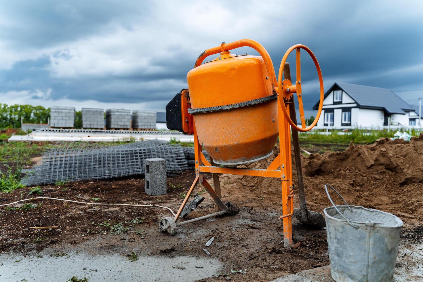 a laranja concreto misturador Onde cimento é preparado para construção trabalho carrinhos em a rua foto