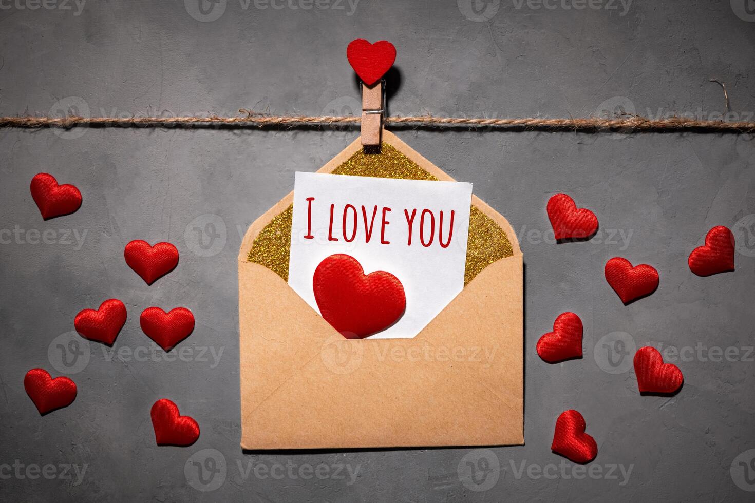 prendedores de roupa com vermelho corações em uma corda em uma cinzento fundo. cartão postal com texto Eu amor você em papel foto