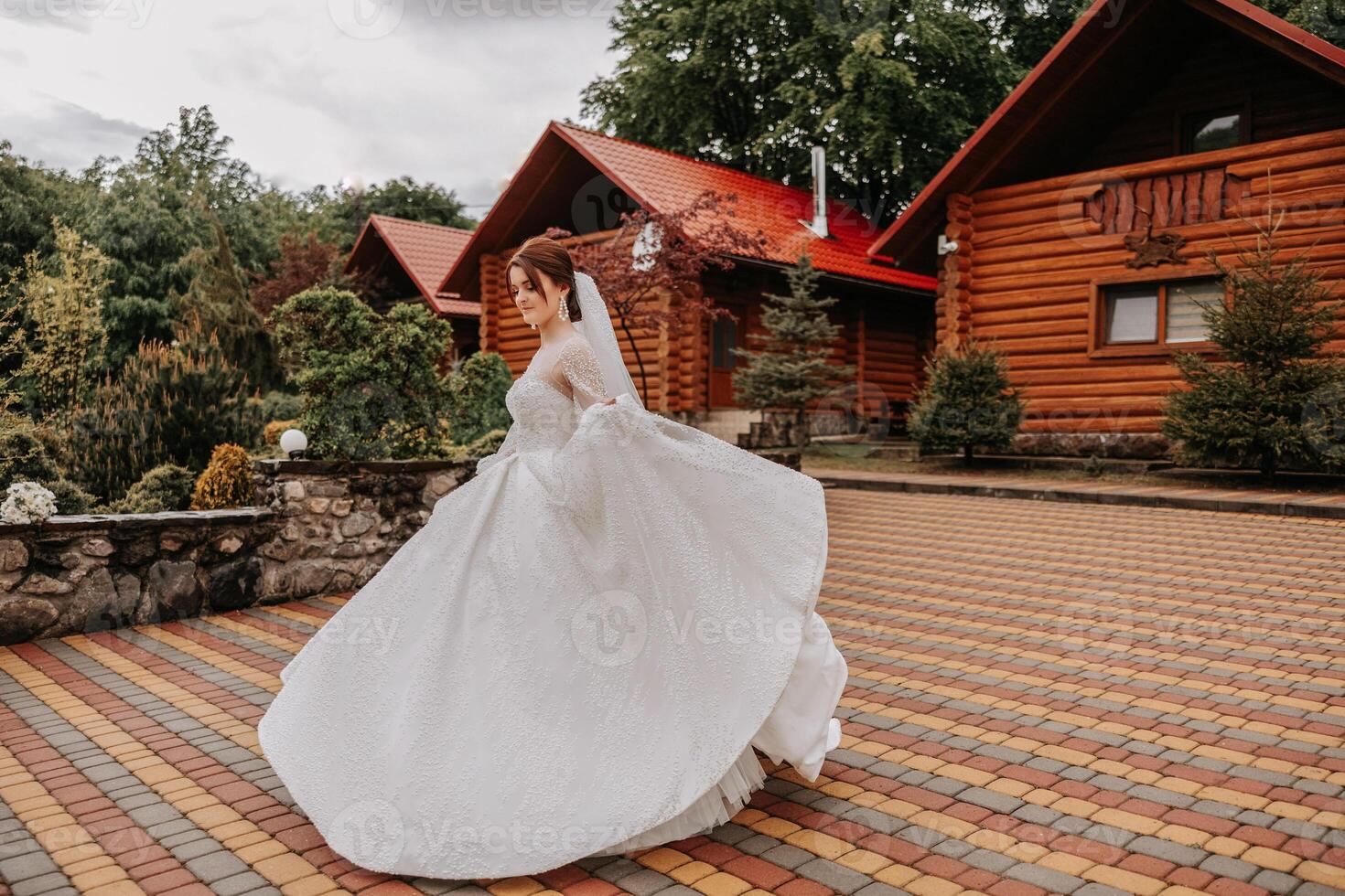 uma ruivo noiva é circulando dentro dela Casamento vestir, contra a fundo do montanhas e de madeira casas. magnífico vestir com grandes mangas, aberto busto. foto