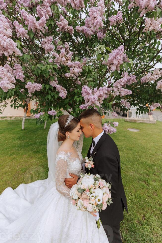 casamento. amor e casal dentro jardim para casamento. a comemorar a cerimônia e compromisso. Salve  a data. confiar. a noiva e noivo abraço contra a fundo do uma Primavera florescendo árvore. foto