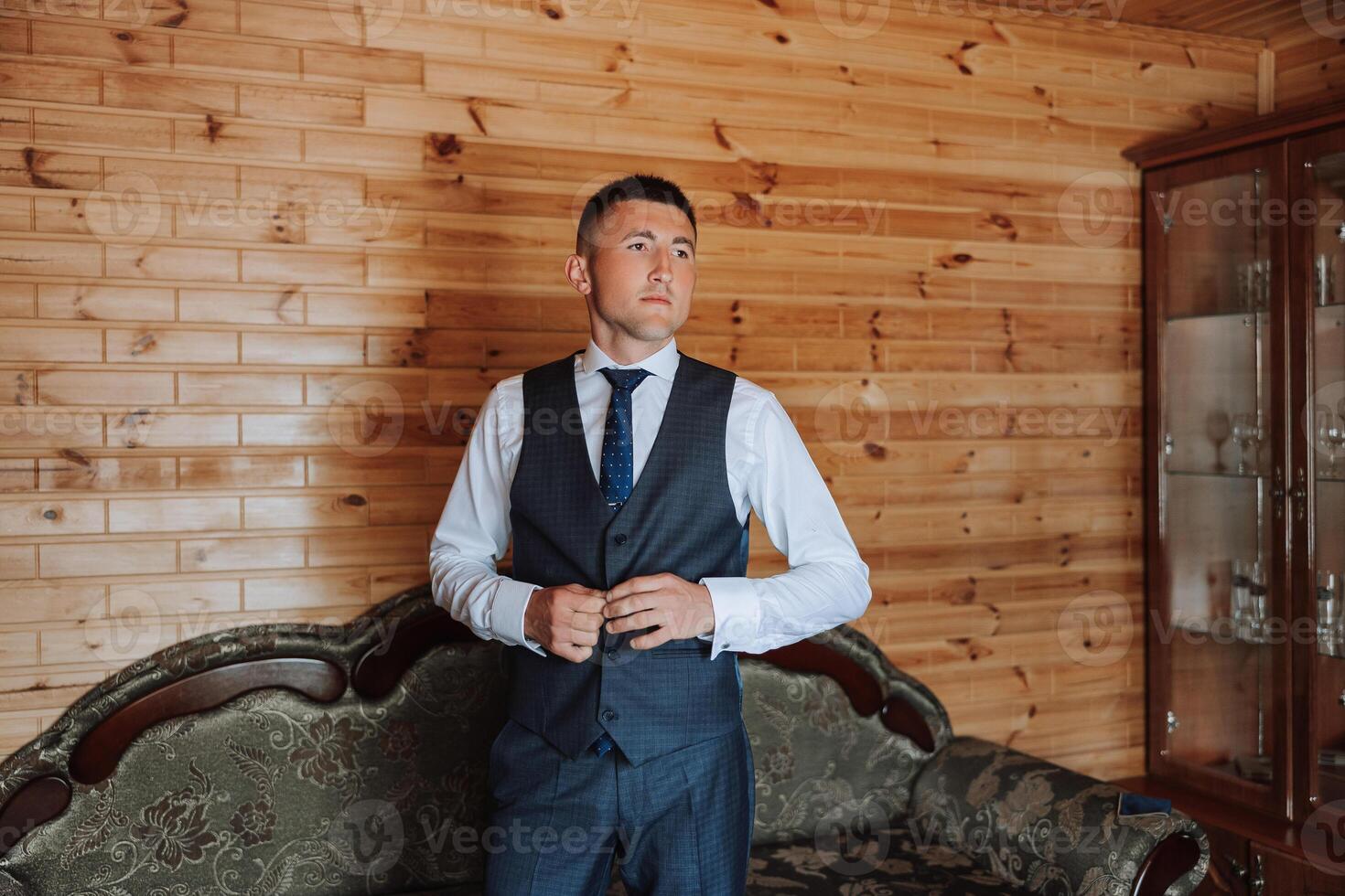 a noivo aperta uma botão em dele colete às a do noivo manhã reuniões. noivo Casamento preparação. foto