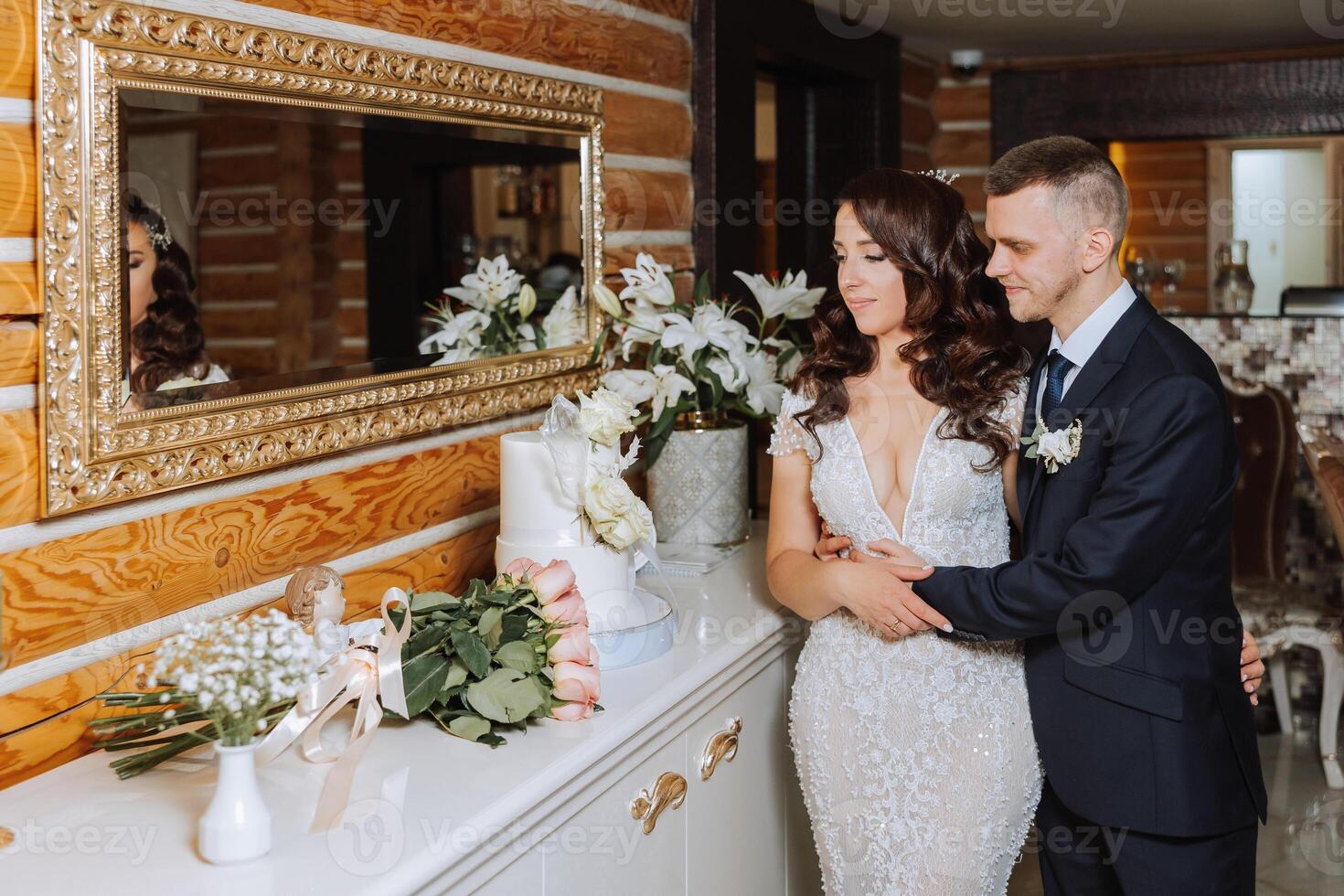 casamento. noivo e noiva perto a Casamento bolo. uma doce e delicioso sobremesa para uma casamento. a noiva cortes a Casamento bolo com a Socorro do dela amante. a noivo abraços dele amado. foto