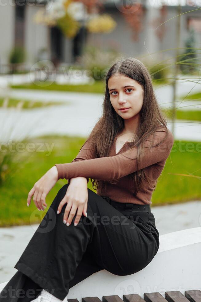 vertical foto. lindo despreocupado jovem Adolescência menina dentro casual roupas. retrato do uma lindo menina contra a fundo do natureza com uma borrado fundo. foto