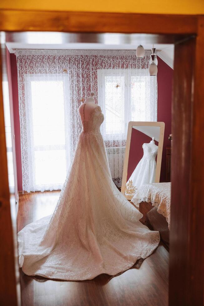 quarto interior com Casamento vestir preparado para a cerimônia. uma lindo exuberante Casamento vestir em uma manequim dentro uma hotel sala. foto