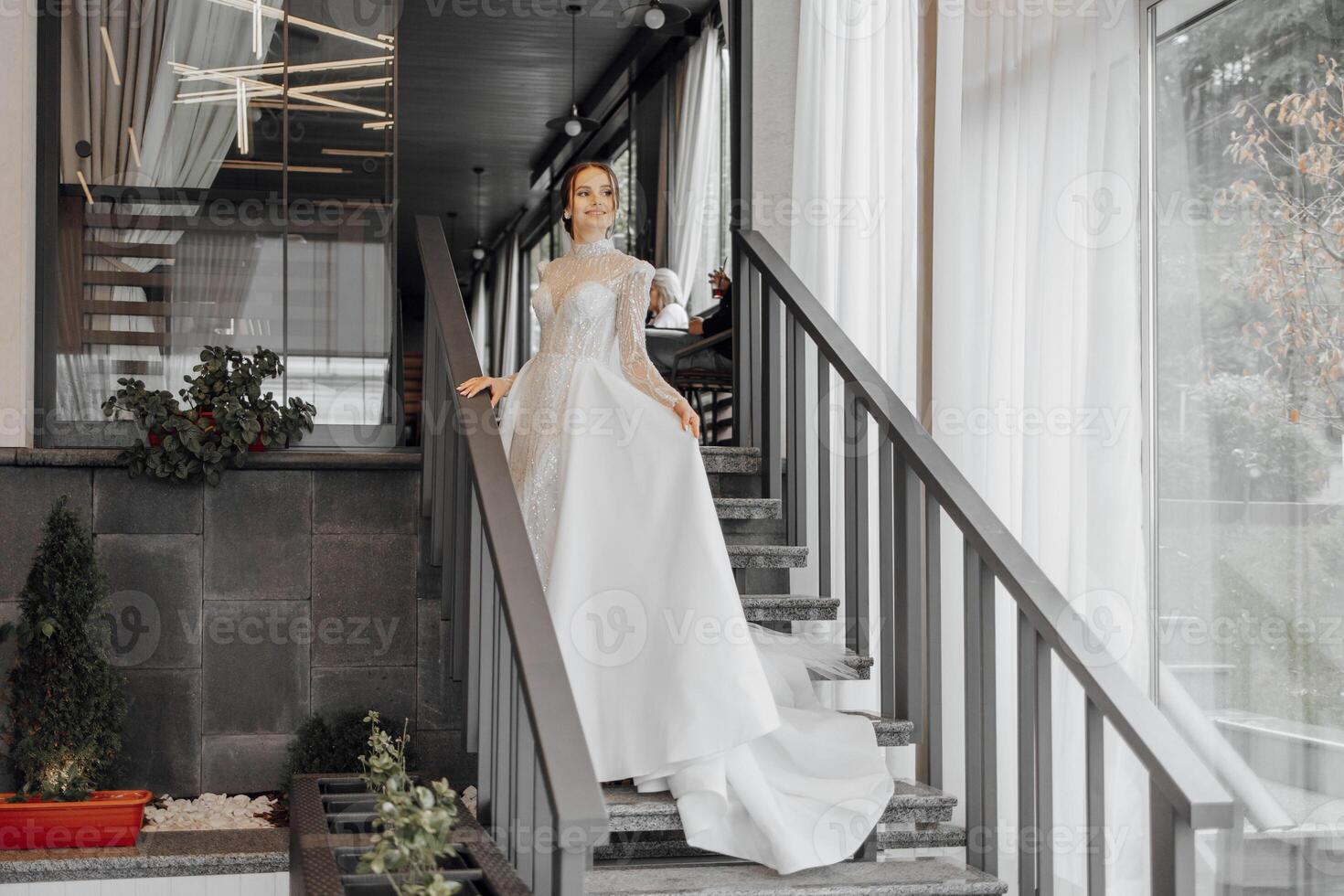 uma comprimento total noiva dentro uma elegante Casamento vestir carrinhos em a passos do uma restaurante e poses para uma fotógrafo. Casamento dia. a melhor evento foto