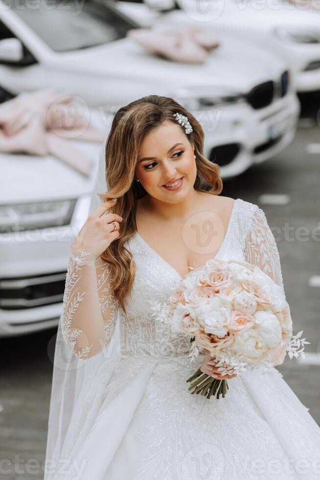 retrato do uma lindo noiva com uma Casamento ramalhete do flores, atraente mulher dentro uma Casamento vestir com uma grandes véu. feliz noiva mulher. noiva com Casamento Maquiagem e penteado. inverno Casamento foto