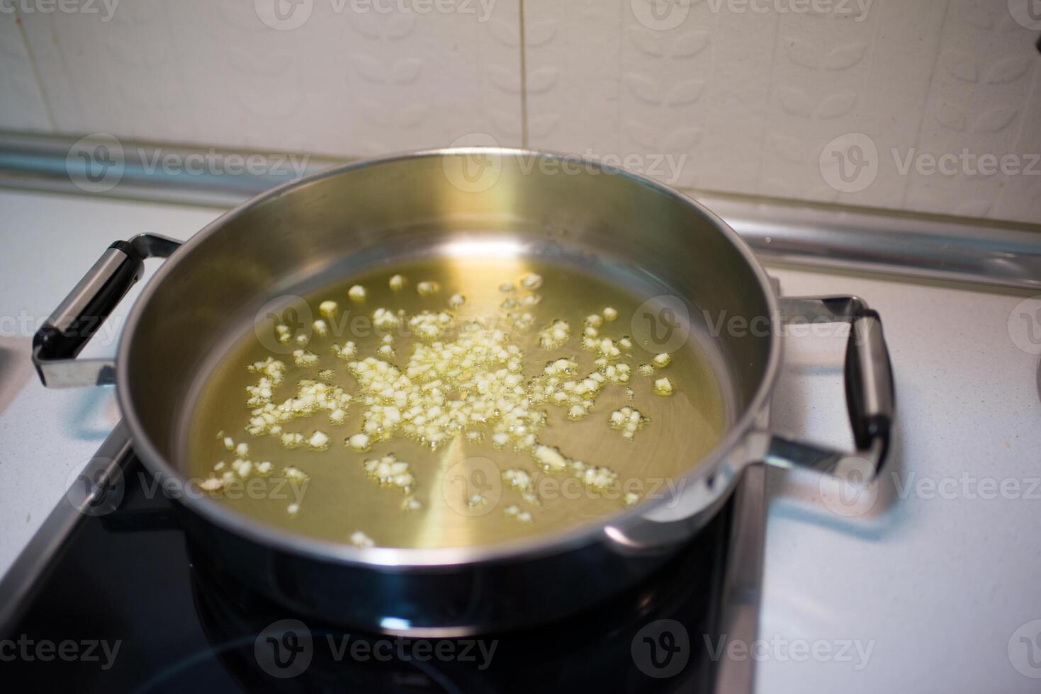 cozinhando Panela com óleo e picado alho foto