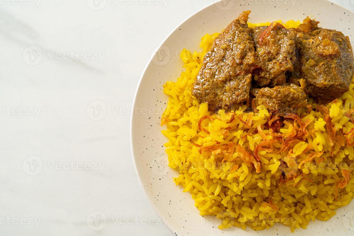 biryani de carne ou arroz com curry e carne - versão tailandês-muçulmana do biryani indiano, com arroz amarelo perfumado e carne bovina foto