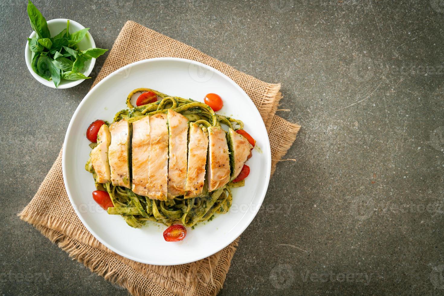 macarrão fettuccine espaguete ao molho pesto com frango grelhado foto