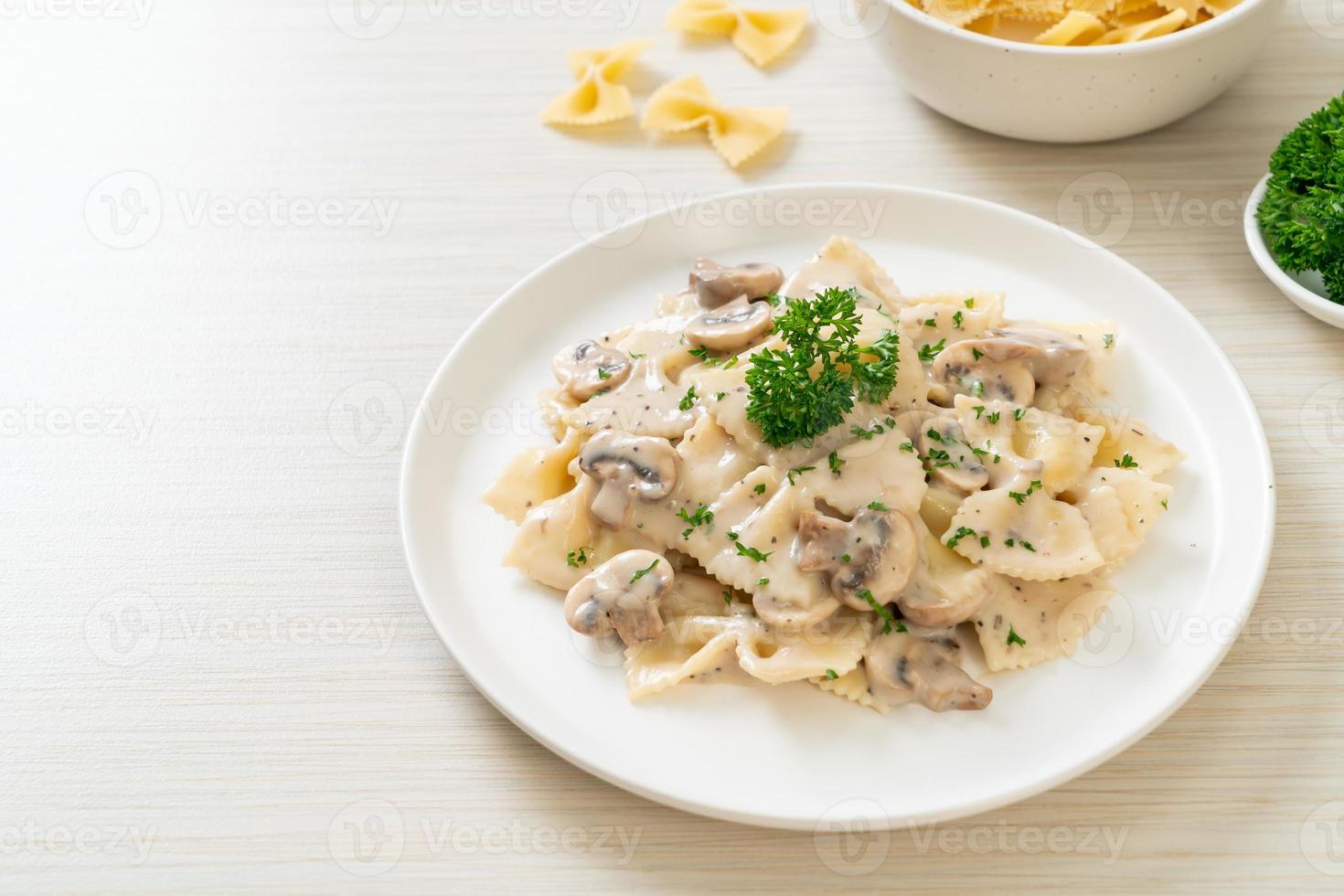 macarrão farfalle com molho de creme de cogumelos branco foto