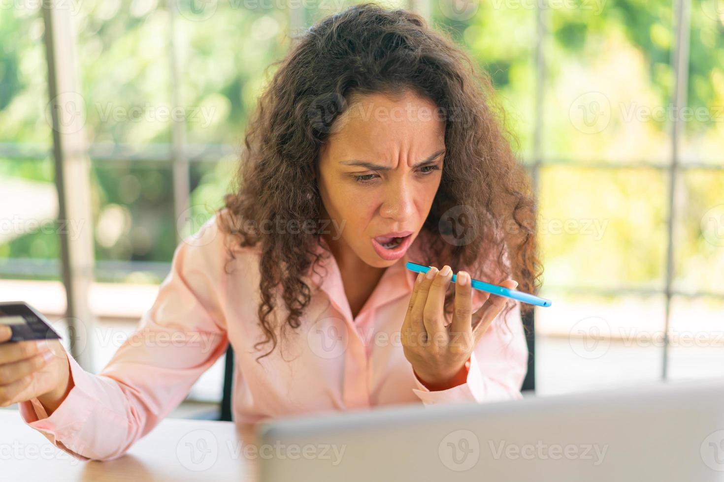 mulher latina trabalhando com a mão segurando um cartão na área de trabalho foto