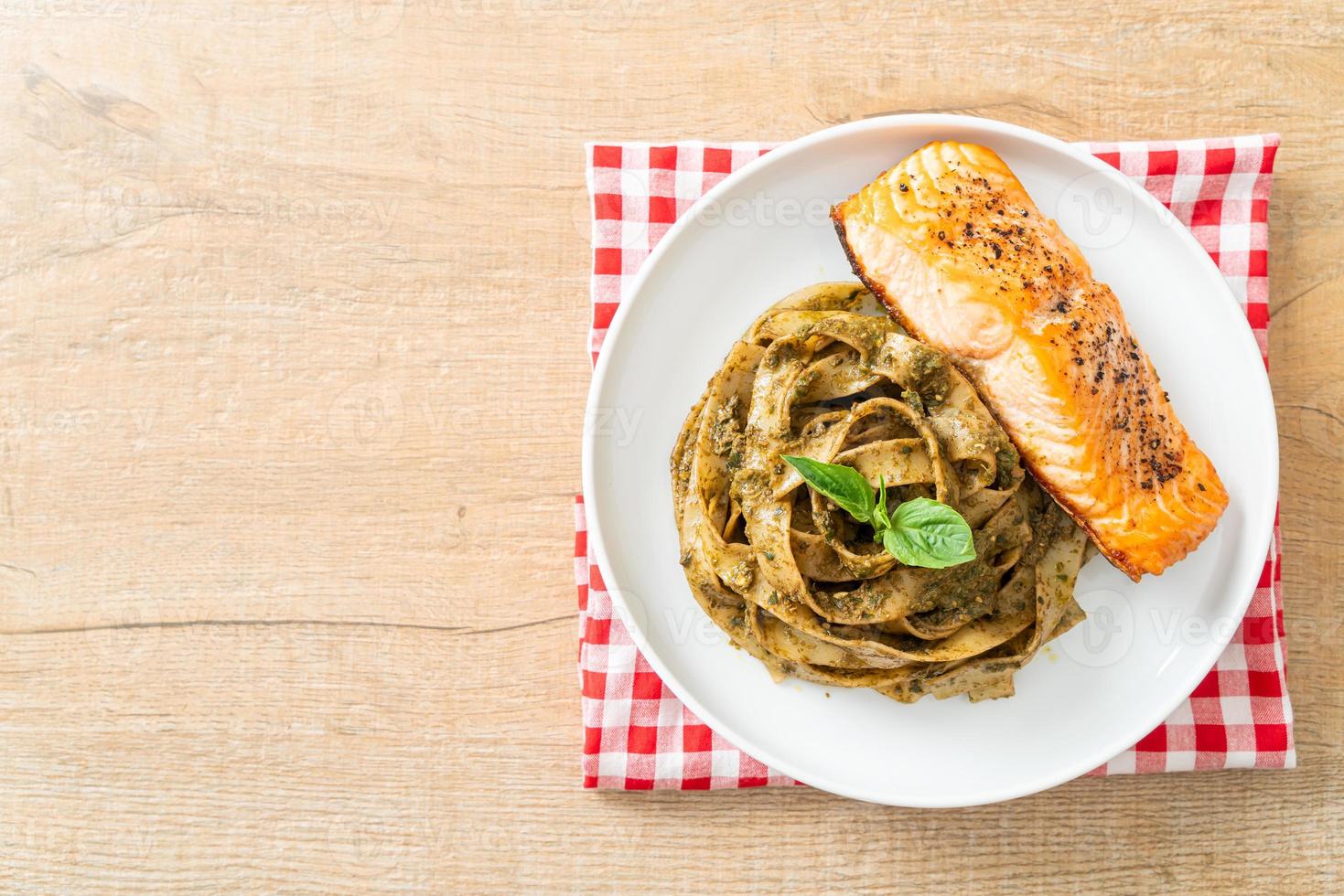 macarrão espaguete pesto fettuccine com filé de salmão grelhado foto