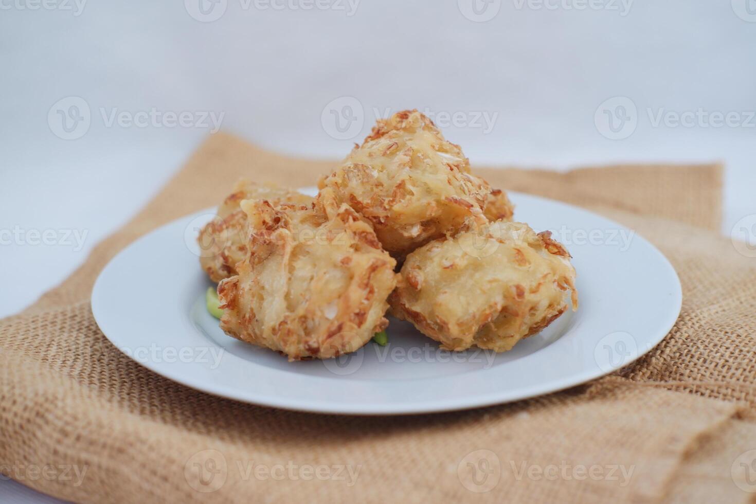 Bakwan Sayur ou vegetal Bolinho de chuva, indonésio lanche fez a partir de farinha, repolho, cenouras e feijão brotos, servido com Pimenta foto