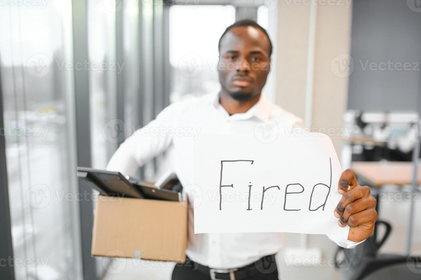 jovem africano homem disparamos segurando caixa com pessoal Itens às o negócio escritório foto