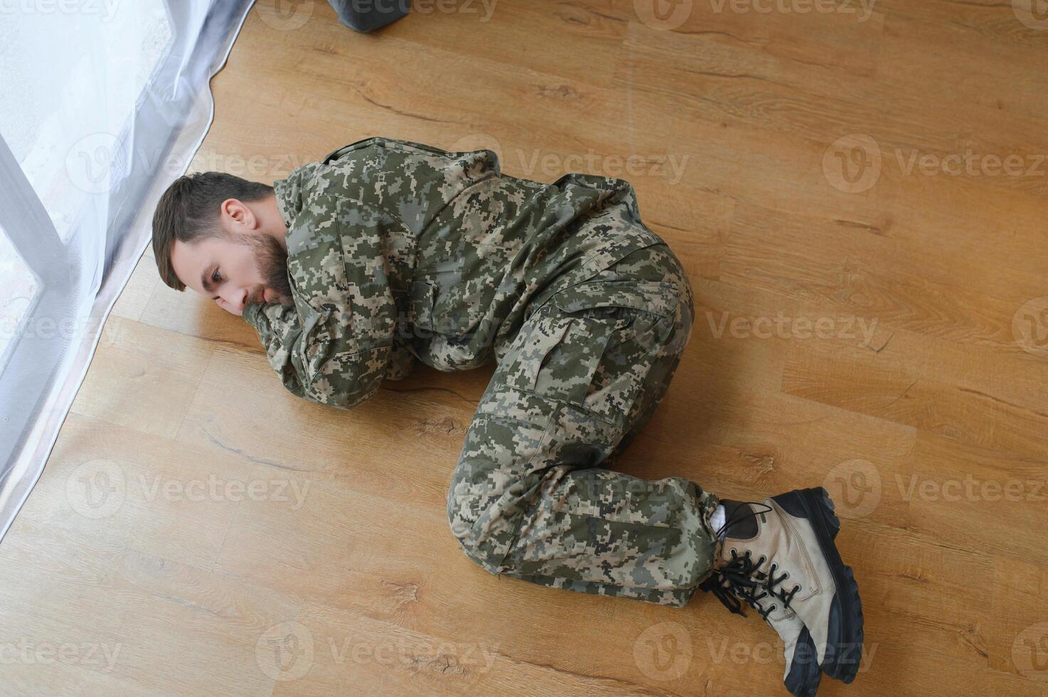 militares homem deitado depressivo em a chão às lar. ptsd foto