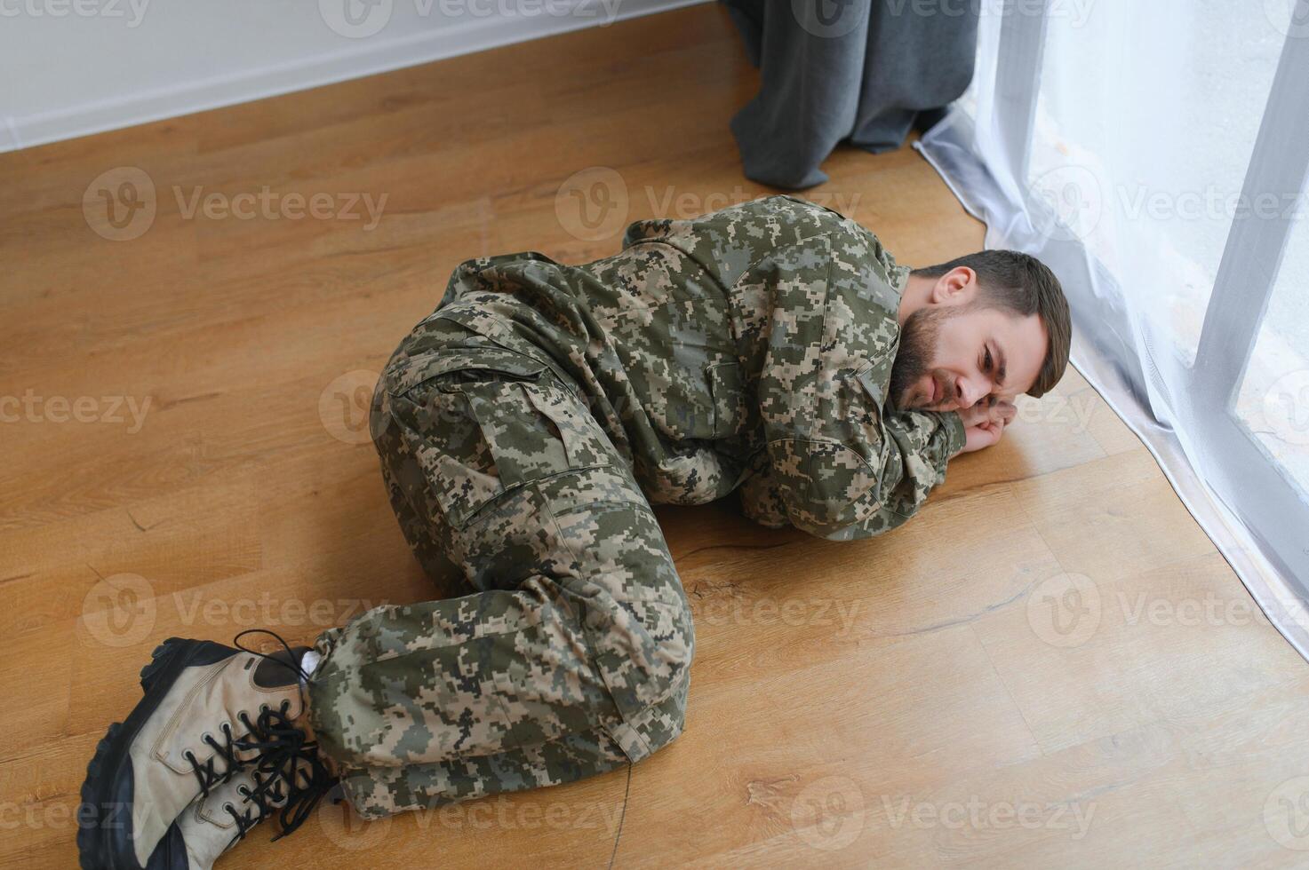 militares homem deitado depressivo em a chão às lar. ptsd foto