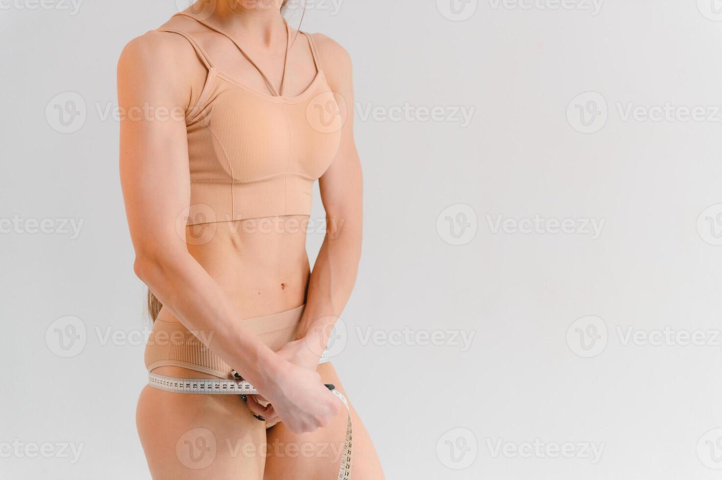 plano estômago com medindo fita. medindo uma mulher cintura com uma medindo fita. foto