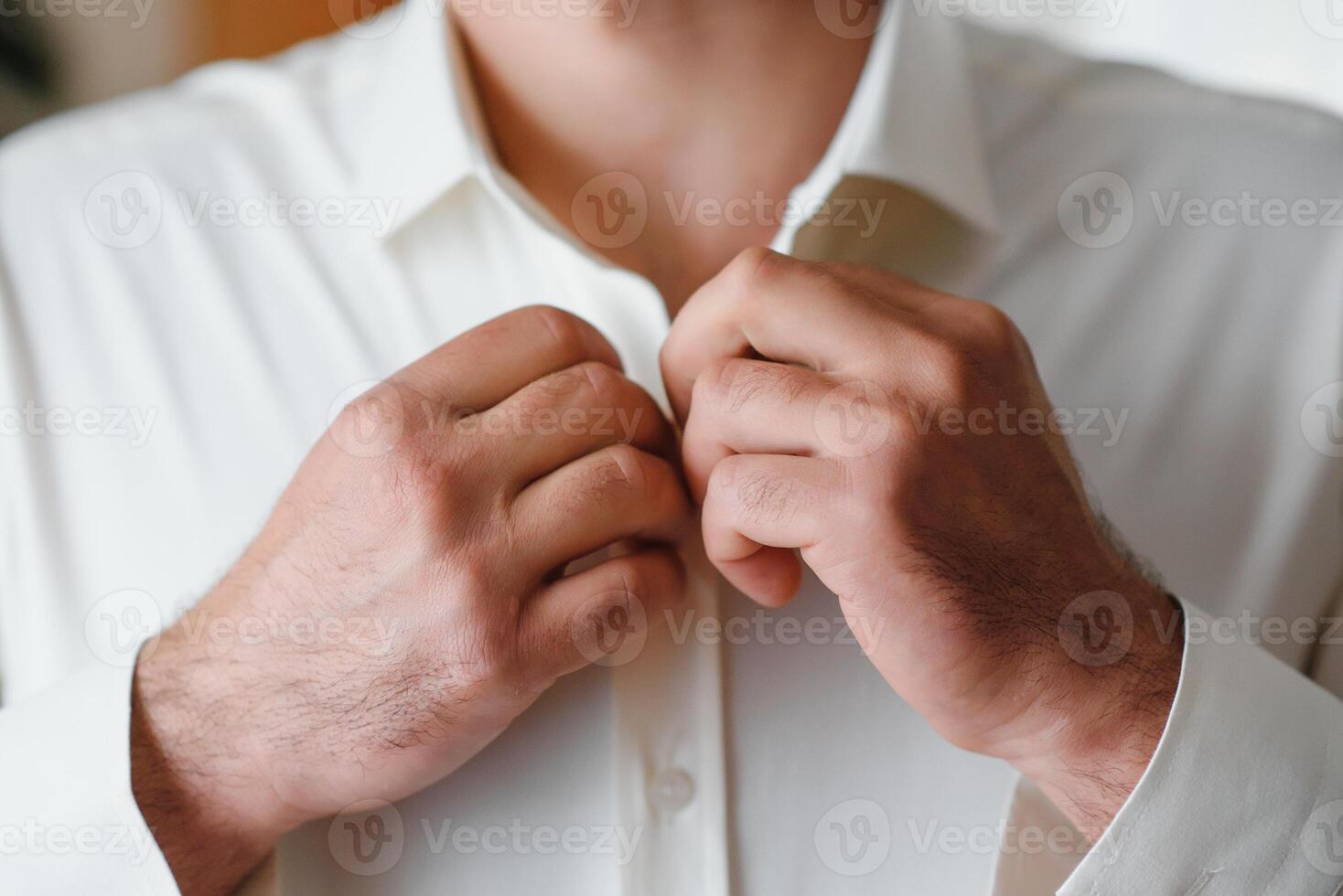 uma homem aperta botões em dele camisa foto