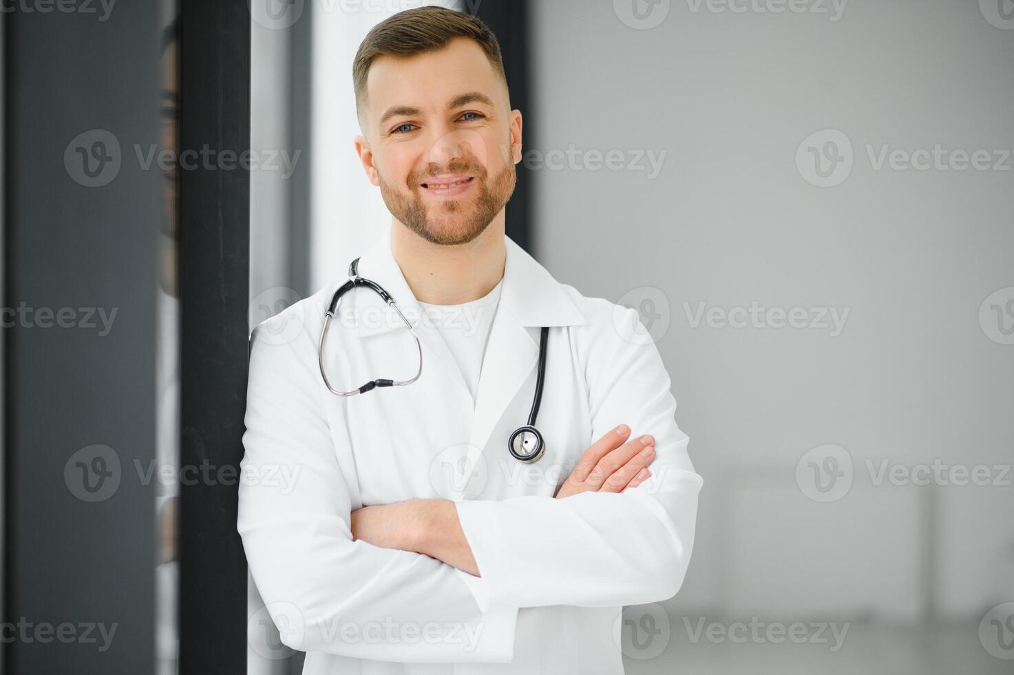 retrato do sorridente médico olhando às Câmera com braços cruzado dentro médico escritório foto