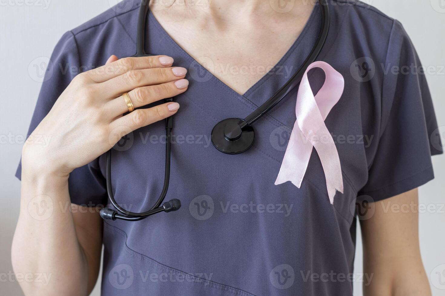 tiro do a fêmea médico contra a branco parede com Rosa fita, Como uma símbolo do uma seio Câncer conhecimento. conceito foto