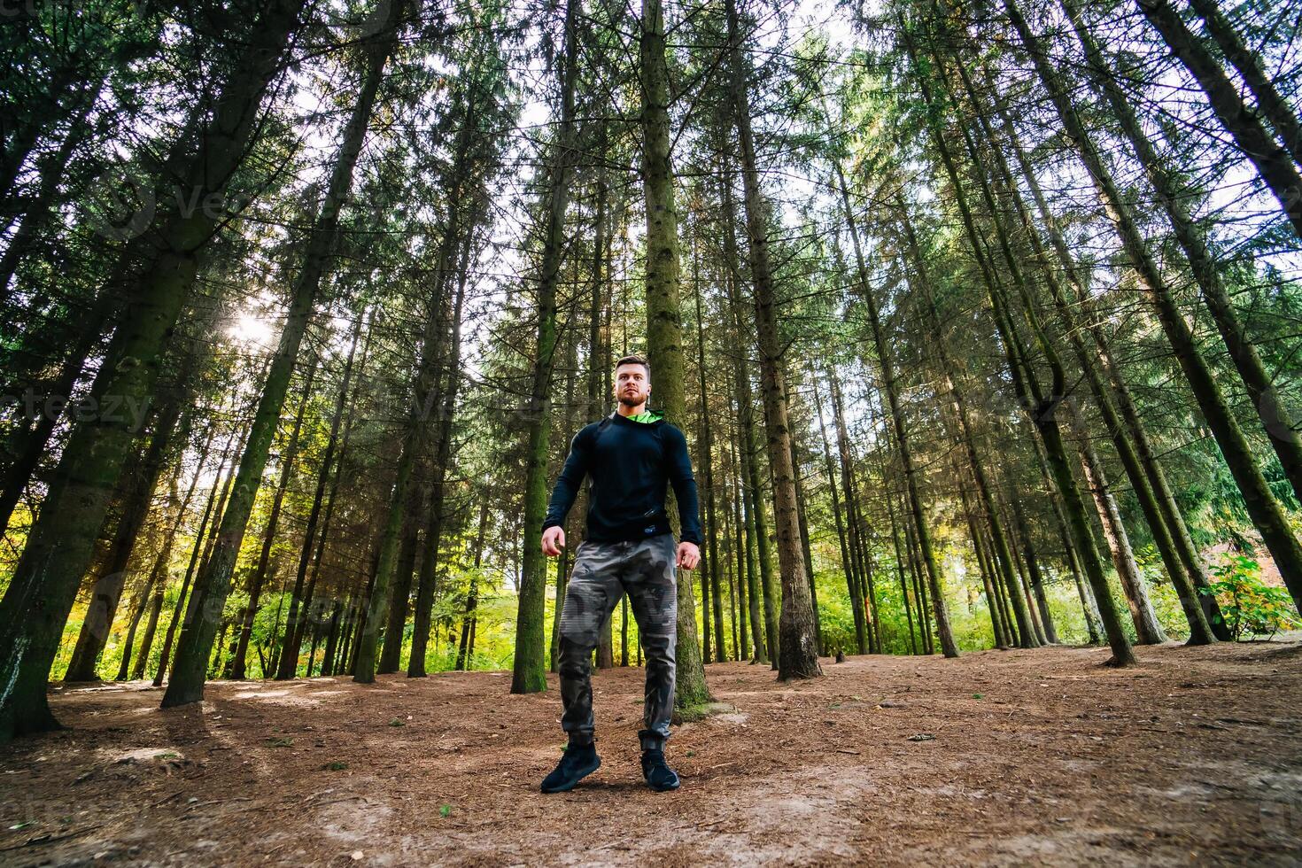 homem em pé majestosamente dentro a coração do natureza. uma homem em pé dentro a meio do uma floresta foto