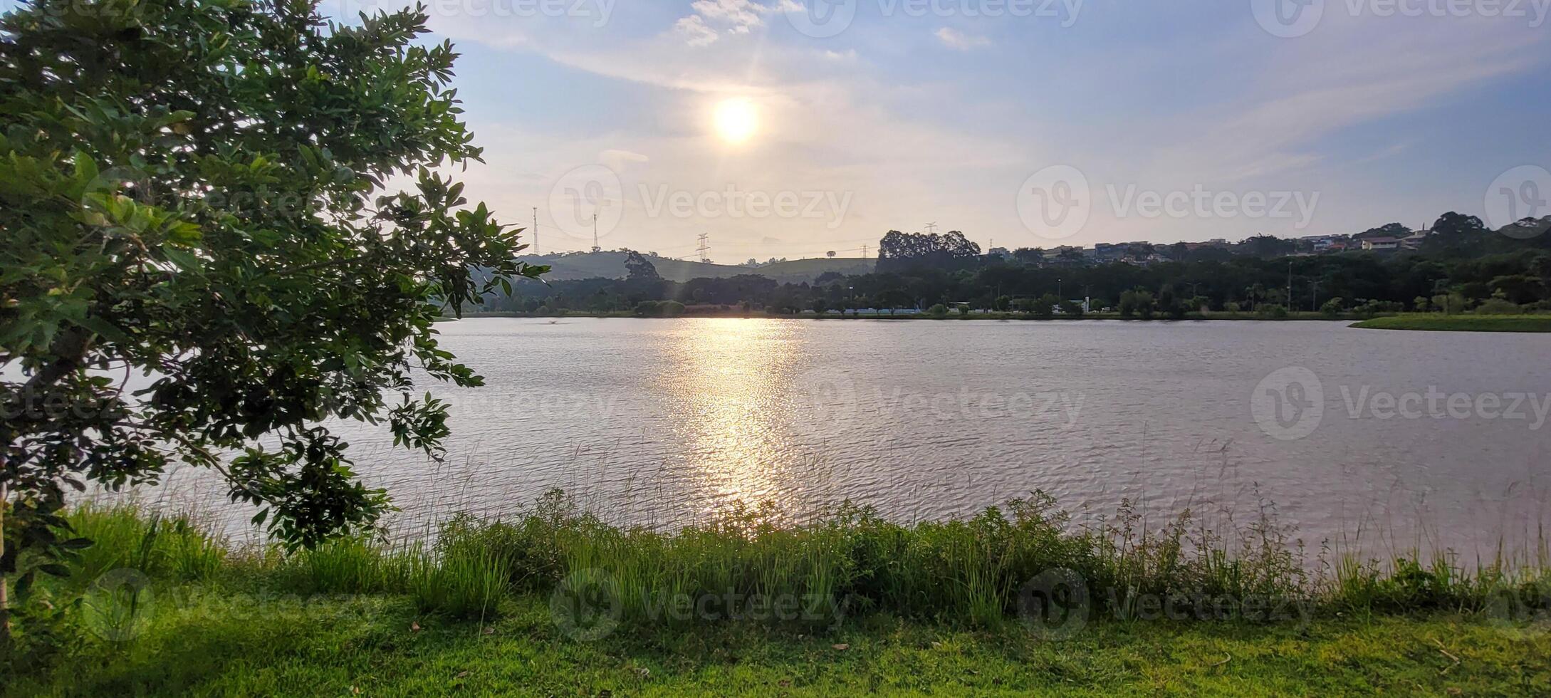 Garoto jogando dentro uma lago dentro uma parque dentro a atrasado tarde com a pôr do sol dentro a fundo foto